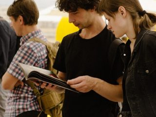 a man and a woman looking at a book